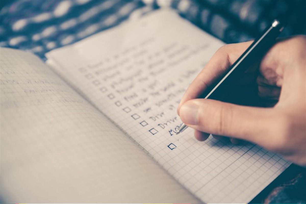 Persona marcando las tareas de una checklist para organizar una mudanza